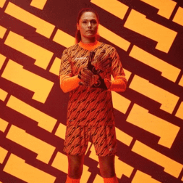 Goalkeeper wearing orange kit.